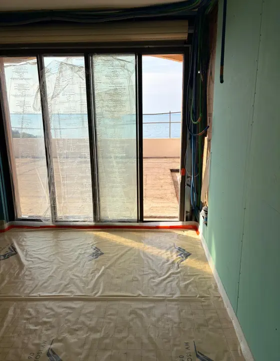 Sol couvert de film devant une baie vitrée