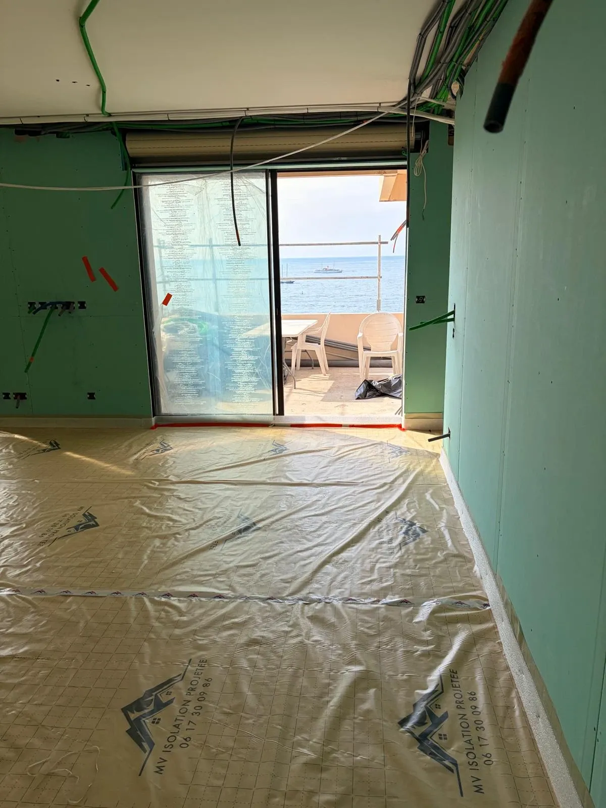 Pièce en travaux avec film MV Isolation au sol et baie ouverte sur la mer
