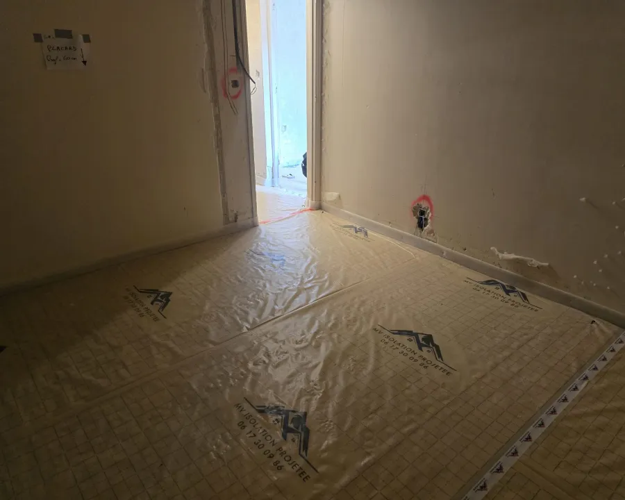 Pièce avec film au sol près d’une porte
