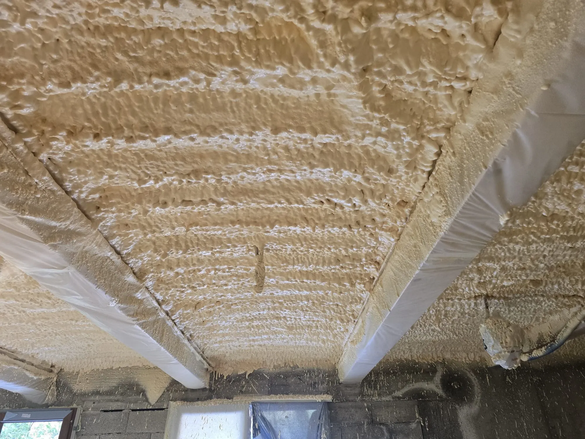 Mousse isolante projetée au plafond entre les poutres protégées sur les hauteurs de Menton